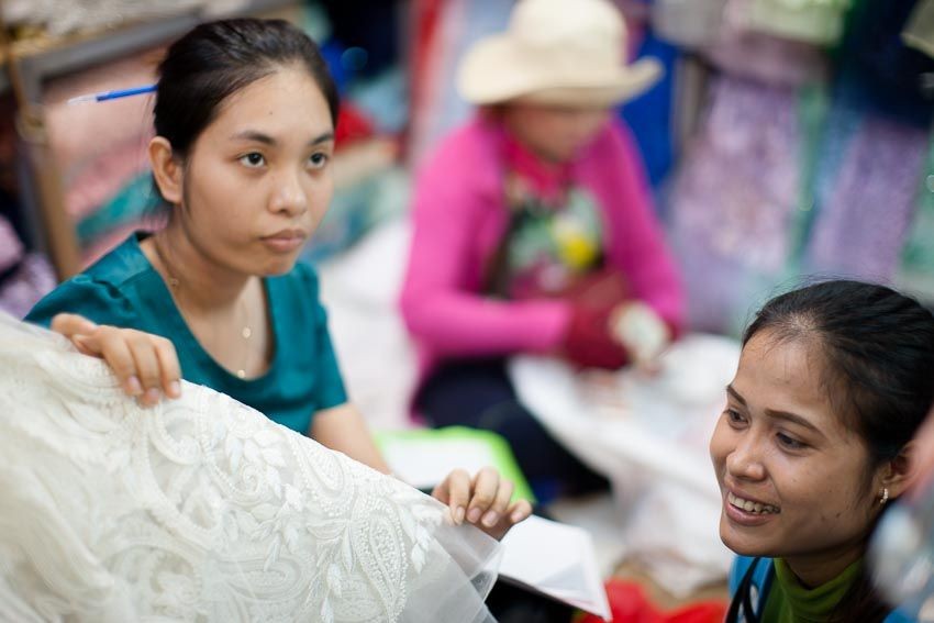 women in the market in Phnom Penh looking at fabrics